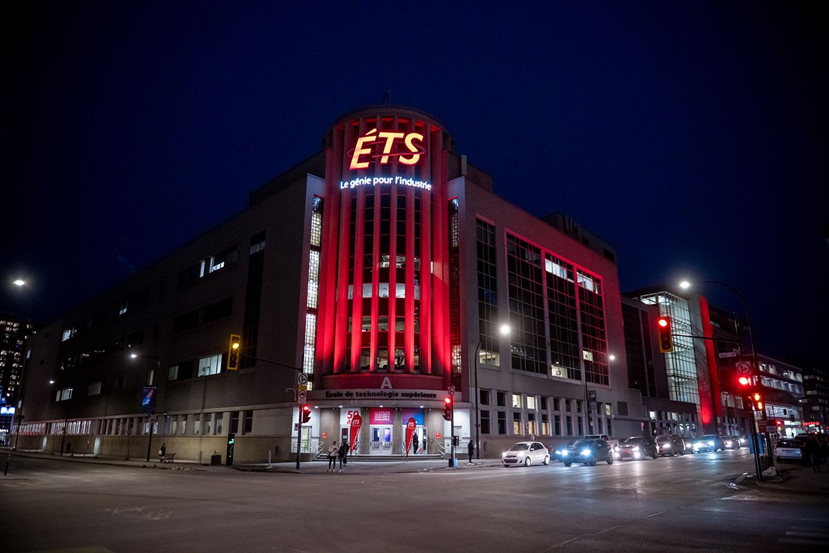 École de technologie supérieure in Montréal at night, its corner tower illuminated in red.
